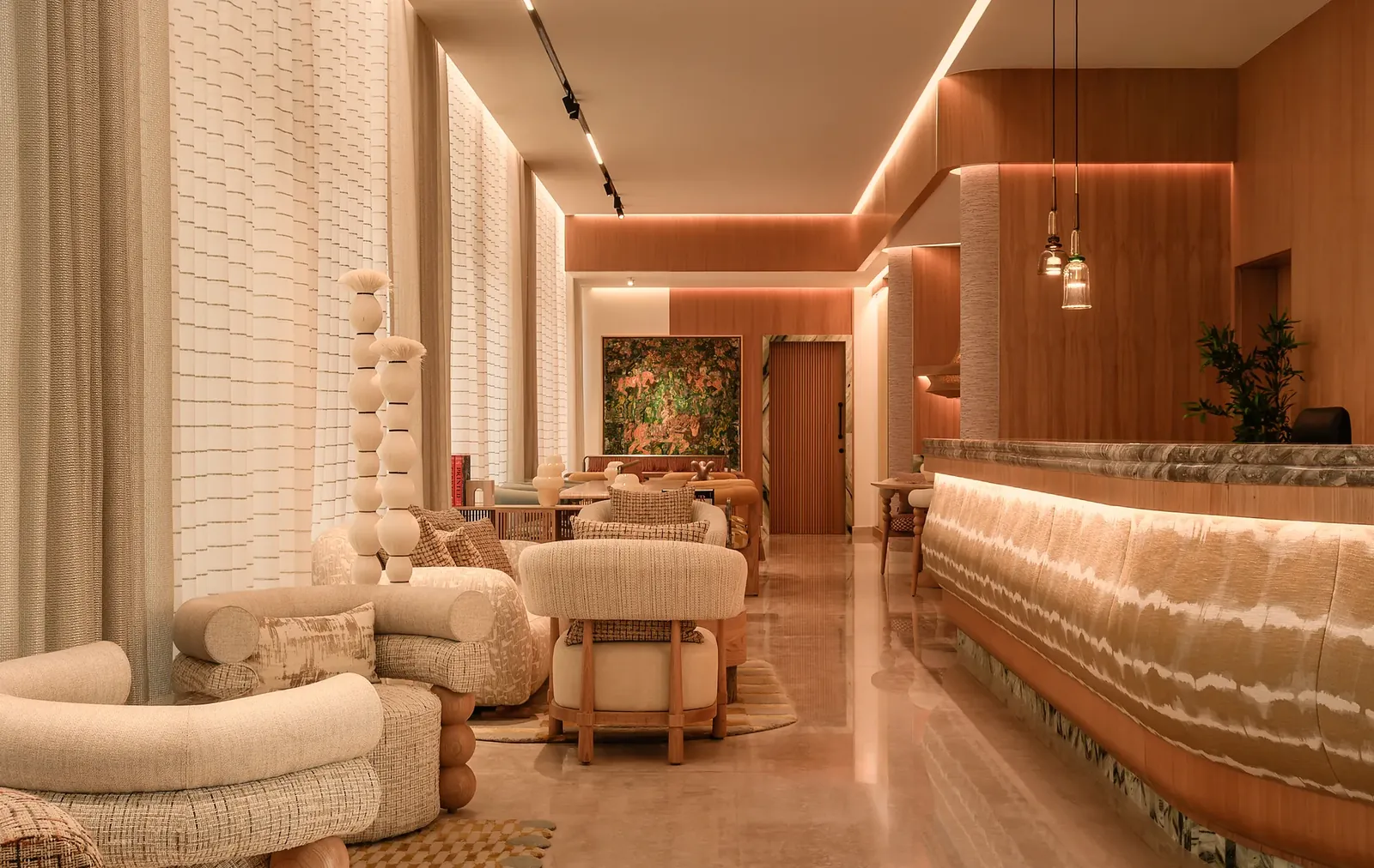 The lobby lounge: sculptural boucle chairs, stacked ceramic totems and a glowing banded-stone reception desk.