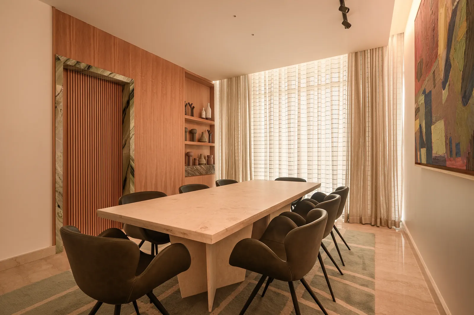 The Z House boardroom: a pale stone table, olive leather chairs, oak panelling and a large abstract painting.